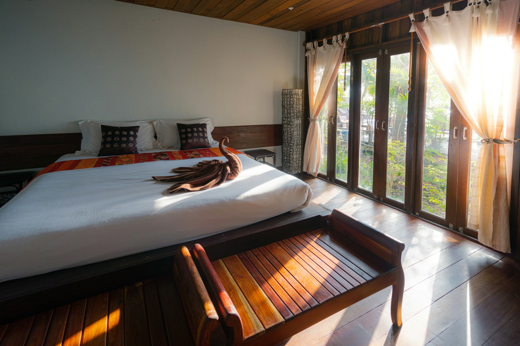 An interior of a calm hospitality space with warm light and patinated surfaces.